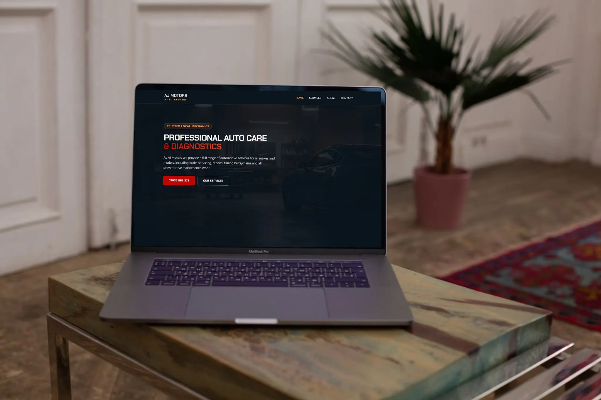 AJ Motors Auto Repairs website shown on a laptop