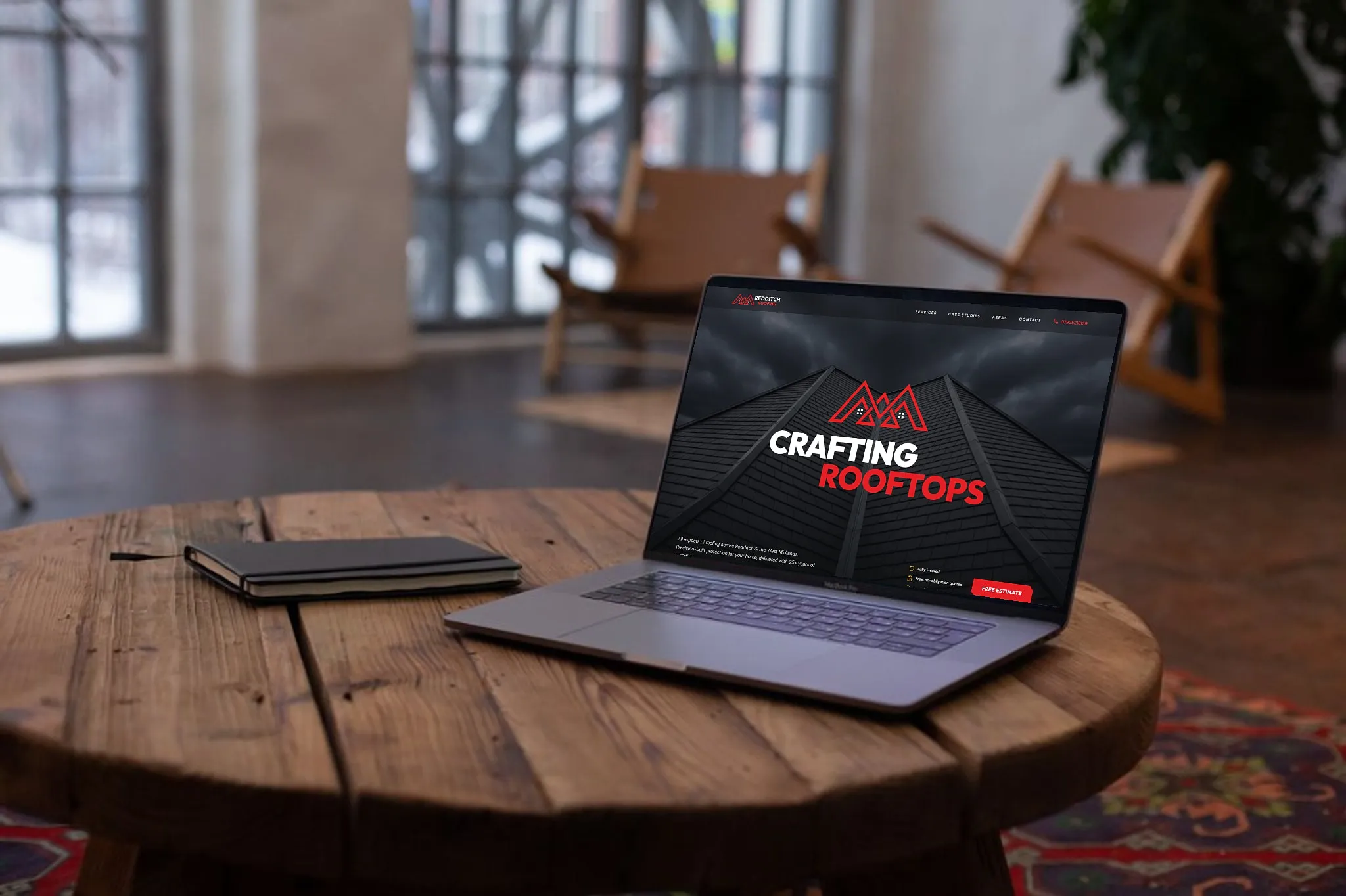 Redditch Roofing Ltd website shown on a laptop in a loft setting